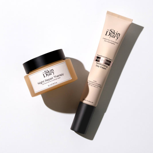 Skin Diary skincare set featuring a Night Repair Therapy jar and an Age Defence Day Cream tube, arranged diagonally on a clean white background with soft shadows.